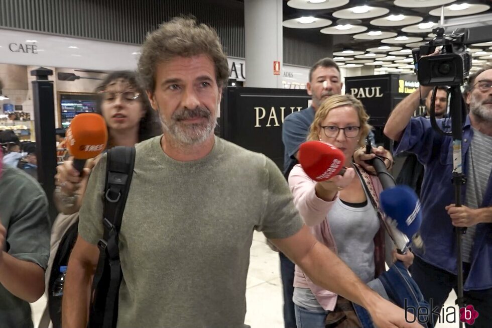 Rodolfo Sancho rodeado de prensa a su llegada a Madrid tras el viaje a Tailandia