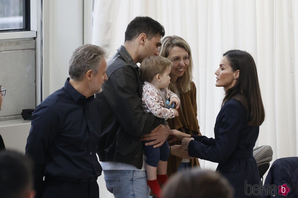 La Reina Letizia hablando con una familia con un niño pequeño en su visita a Valencia para apoyar a las víctimas del incendio