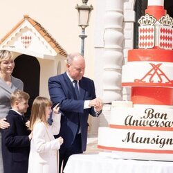 Alberto de Mónaco cortando su tarta de cumpleaños ante Charlene de Mónaco y sus hijos 