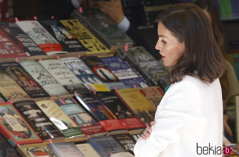 La Reina Letizia ve algunos ejemplares durante la Feria del Libro