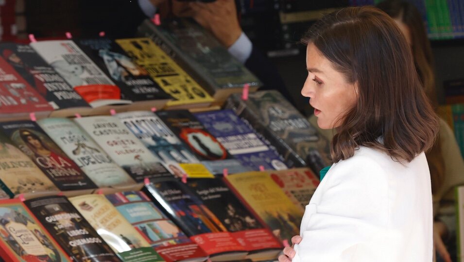 La Reina Letizia ve algunos ejemplares durante la Feria del Libro