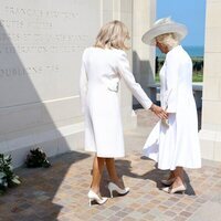 Brigitte Macron tratando de coger de la mano a la Reina Camilla en el 80 aniversario del Desembarco de Normandía