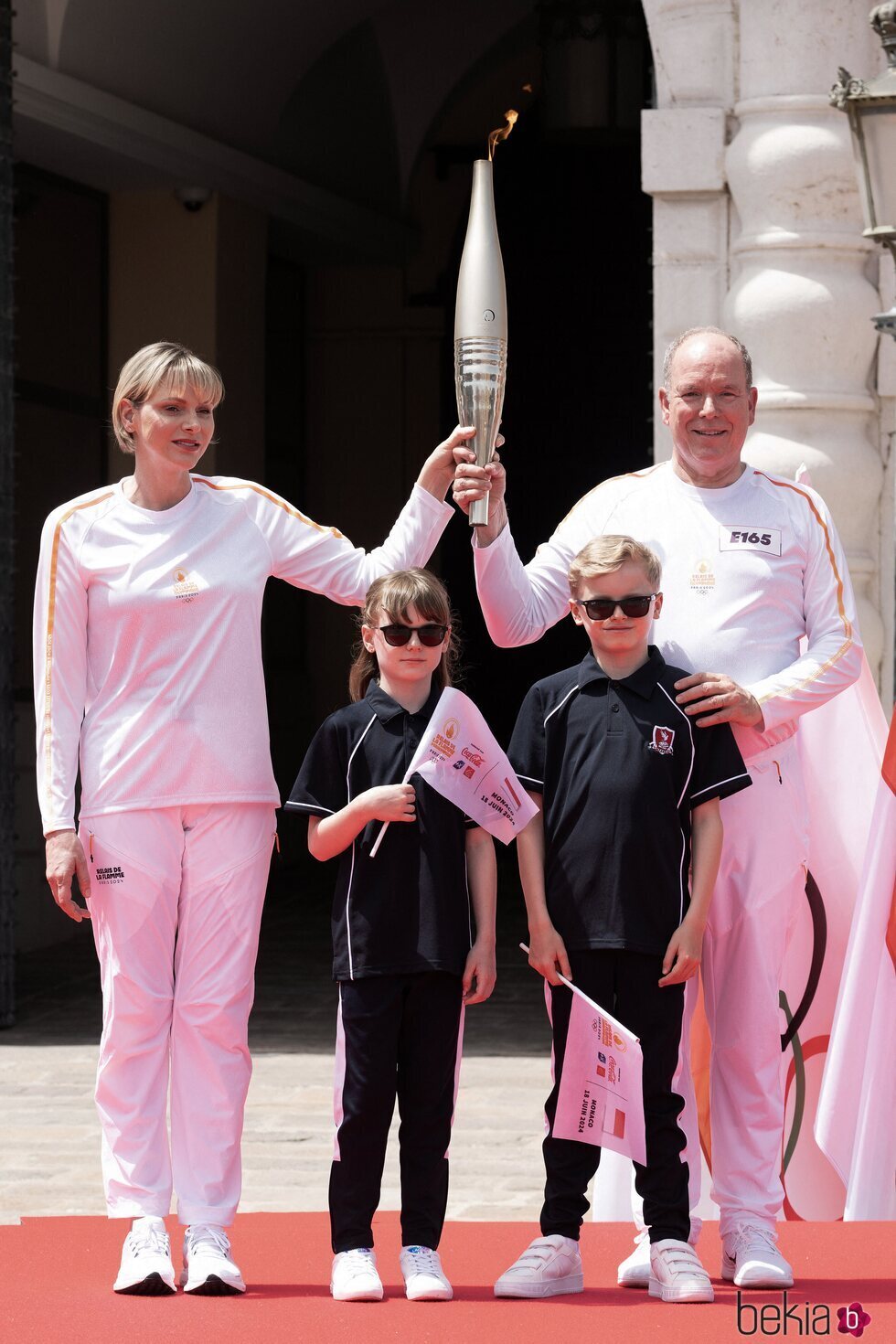 Alberto y Charlene de Mónaco y sus hijos Jacques y Gabriella con la antorcha olímpica de París 2024