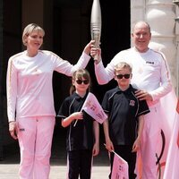 Alberto y Charlene de Mónaco y sus hijos Jacques y Gabriella con la antorcha olímpica de París 2024