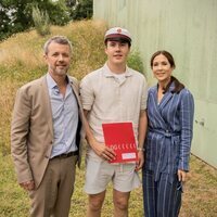 Christian de Dinamarca con su diploma en su graduación junto a sus padres 