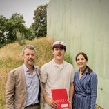 Christian de Dinamarca con su diploma en su graduación junto a sus padres 