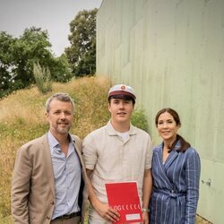 Christian de Dinamarca con su diploma en su graduación junto a sus padres 