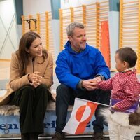 Federico y Mary de Dinamarca con un niño en su primera visita oficial a Groenlandia como Reyes