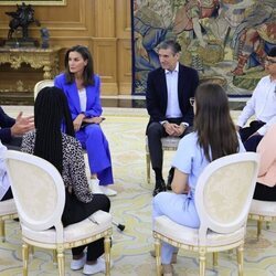 La Reina Letizia sentada con los participantes de la audiencia a una representación de la Fundación Microfinanzas BBVA