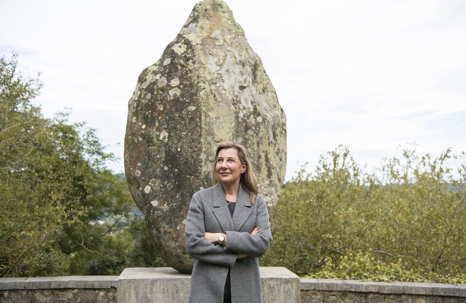 Eva García Saénz de Urturi en el monolito de las Cuevas del Monte Castillo