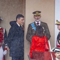 El Rey Felipe junto a Pedro Sánchez y Margarita Robles en pleno momento de lluvia en el Día de la Hispanidad 2024