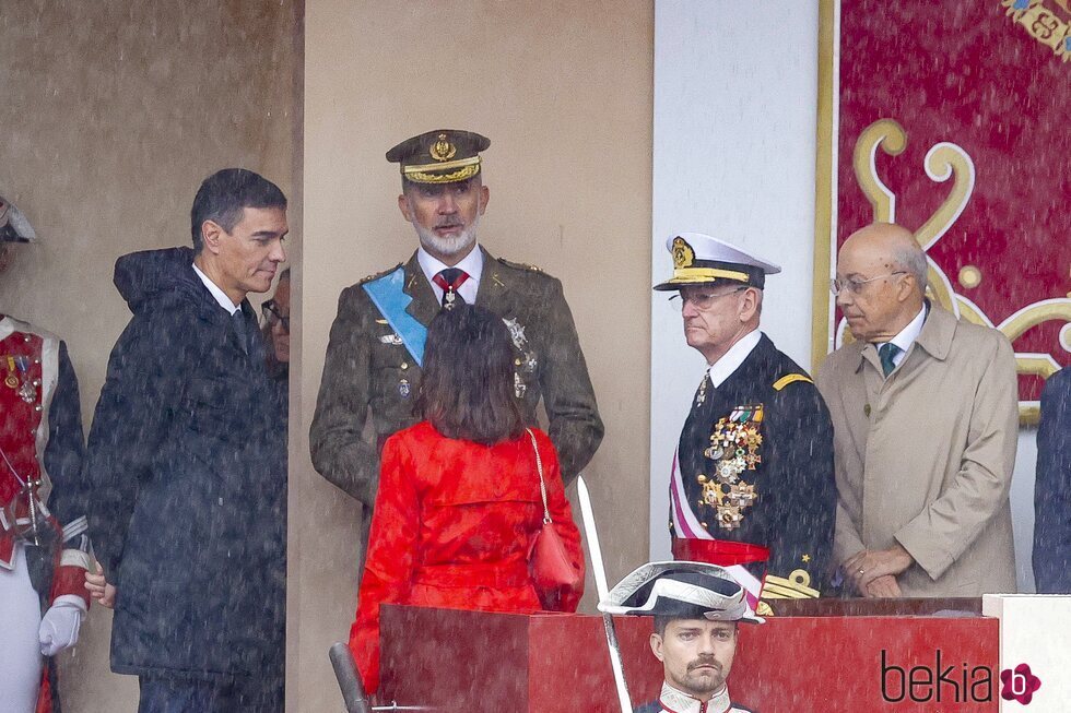 El Rey Felipe junto a Pedro Sánchez y Margarita Robles en pleno momento de lluvia en el Día de la Hispanidad 2024