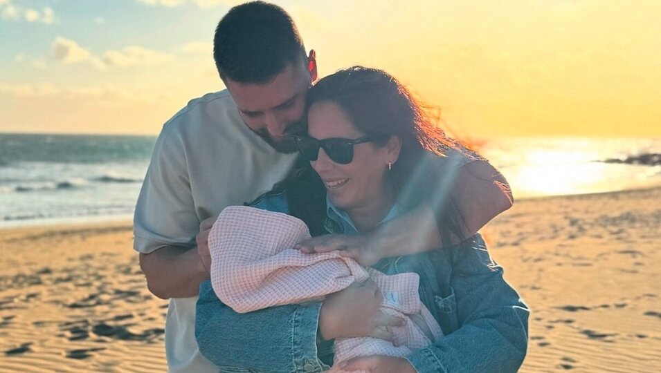 Anabel Pantoja y David Rodríguez con su hija Alma en brazos en la playa