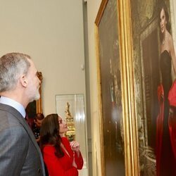 Los Reyes Felipe y Letizia mirando los retratos realizados por Annie Leibovitz para el Banco de España