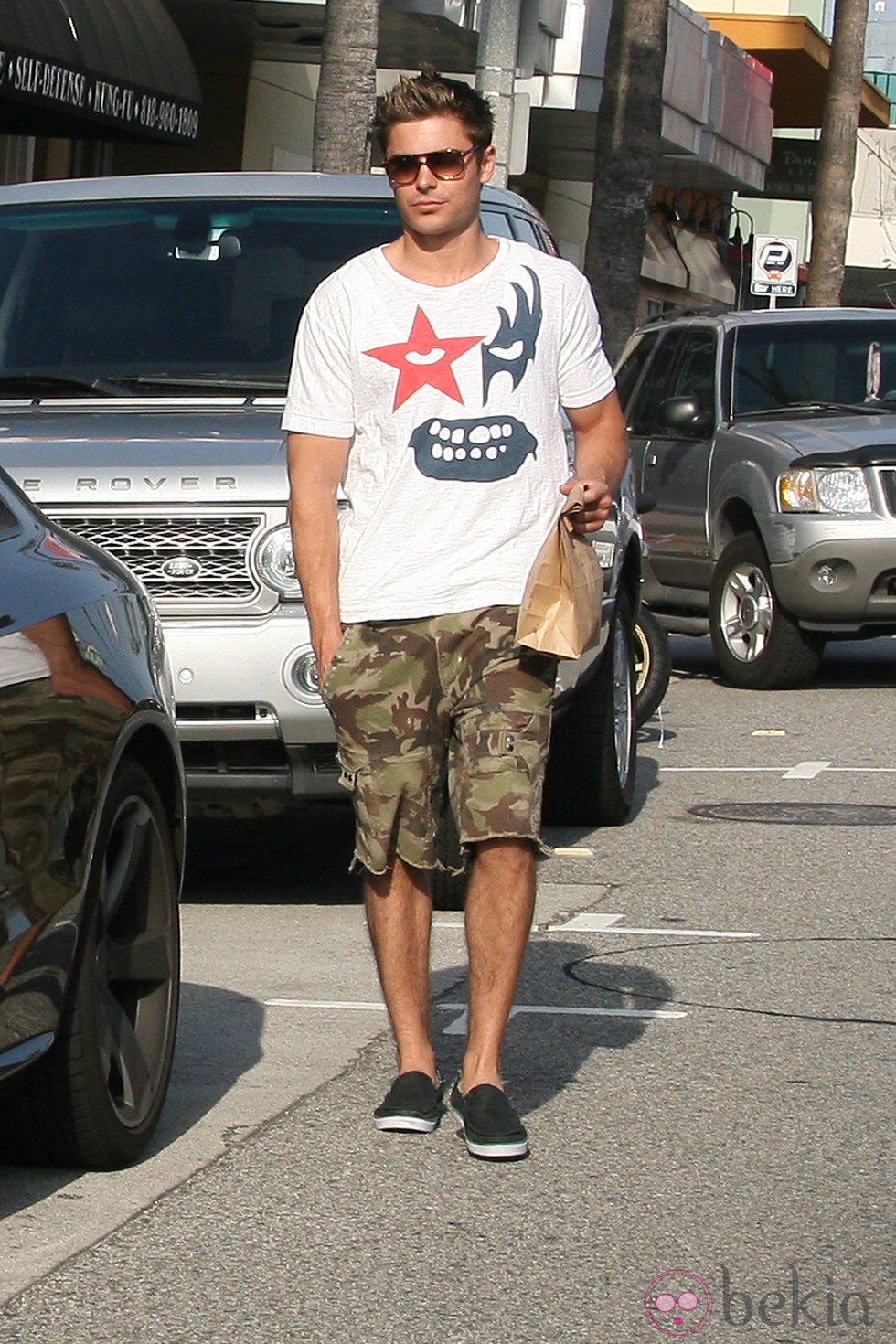 Zac Efron con gafas de sol y pantalones militares