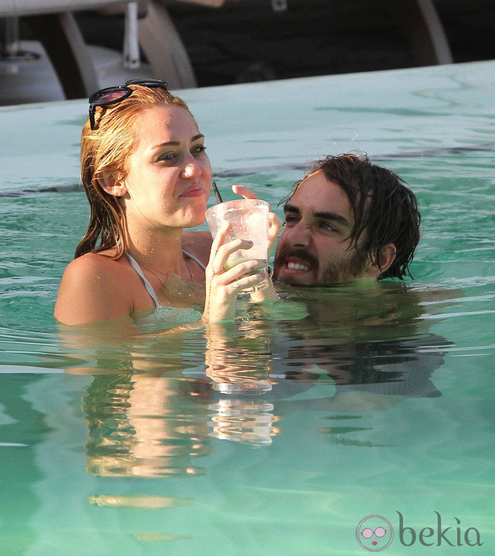 Miley Cyrus en bikini se divierte en la piscina con un amigo