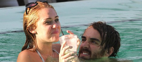 Miley Cyrus en bikini se divierte en la piscina con un amigo