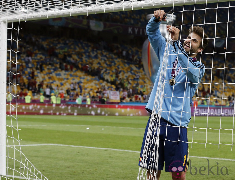 Gerard Piqué corta la red de la portería tras la victoria de la Eurocopa 2012