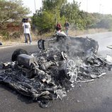 Un bombero echa agua sobre el Ferrari calcinado de Ever Banega