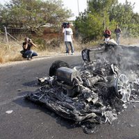 Un bombero echa agua sobre el Ferrari calcinado de Ever Banega