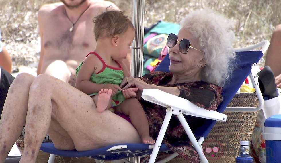 Cayetana de Alba sostiene a un bebé durante un día de playa