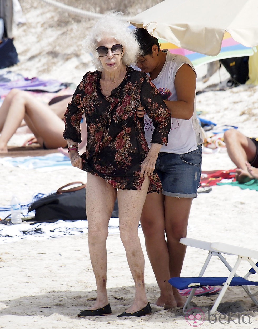 La Duquesa de Alba con su asistenta en la playa