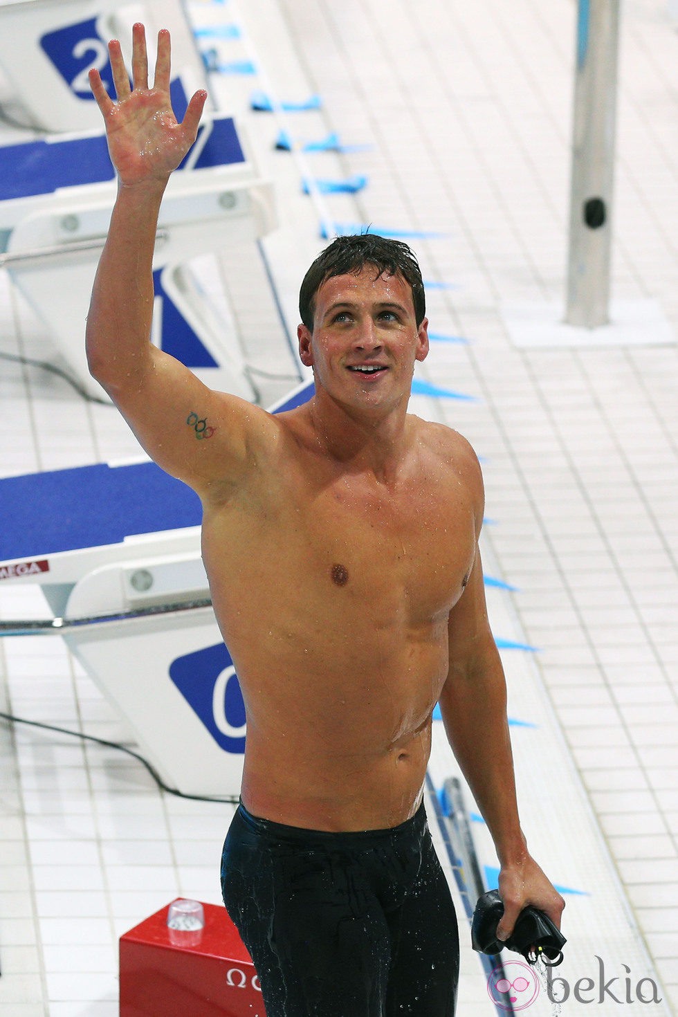 Ryan Lochte saluda con el torso desnudo