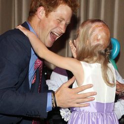 El Príncipe Harry abraza a una niña en los premios de la Fundación Wellchild