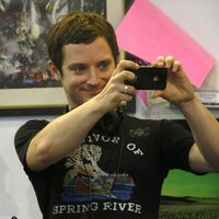 Elijah Wood sonríe con su iPhone