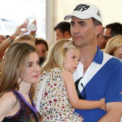 Don Felipe sostiene a la Infanta Sofía junto a Doña Letizia en el concierto de Jaime Anglada