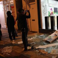 Varias personas fotografían una tienda saqueada en los disturbios de Londres