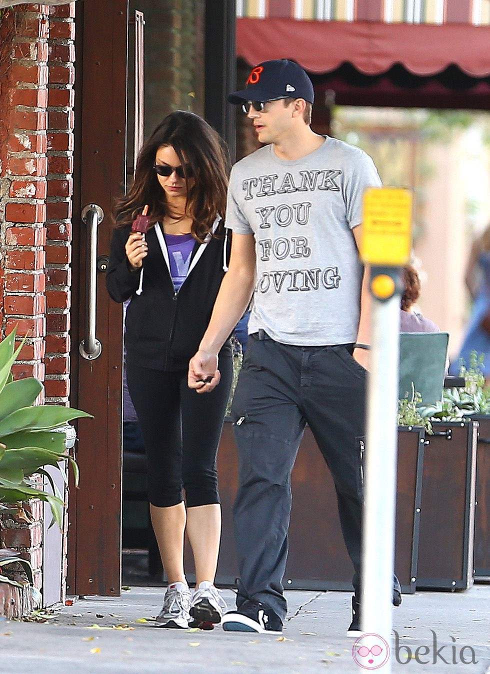 Mila Kunis y Ashton Kutcher comiendo un helado mientras pasean