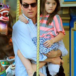 Tom Cruise con Suri en brazos en un tiovivo