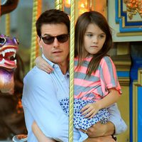 Tom Cruise con Suri en brazos en un tiovivo