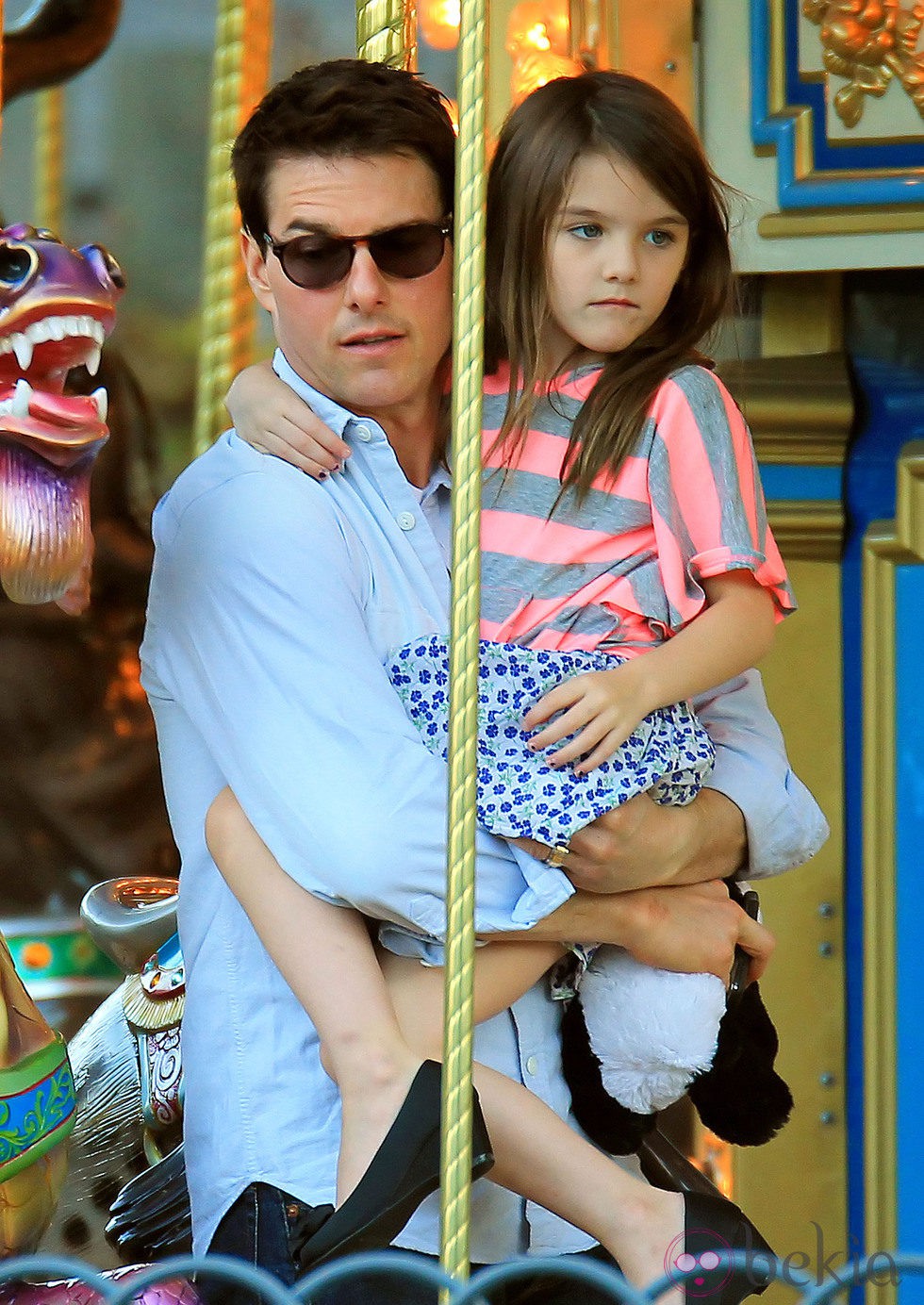 Tom Cruise con Suri en brazos en un tiovivo