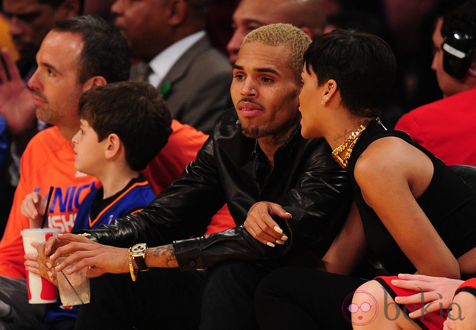 Rihanna agarrada a Chris Brown durante el partido de la NBA