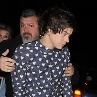 Harry Styles es ayudado por un guardaespalda a la salida de su cumpleaños