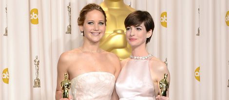 Jennifer Lawrence y Anne Hathaway posando con sus galardones en los Oscar 2013