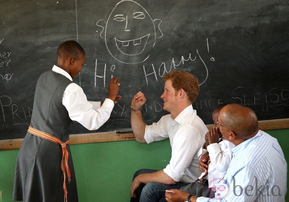 Un niño escribe en la pizarra junto al Príncipe Harry en Lesotho