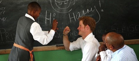 Un niño escribe en la pizarra junto al Príncipe Harry en Lesotho