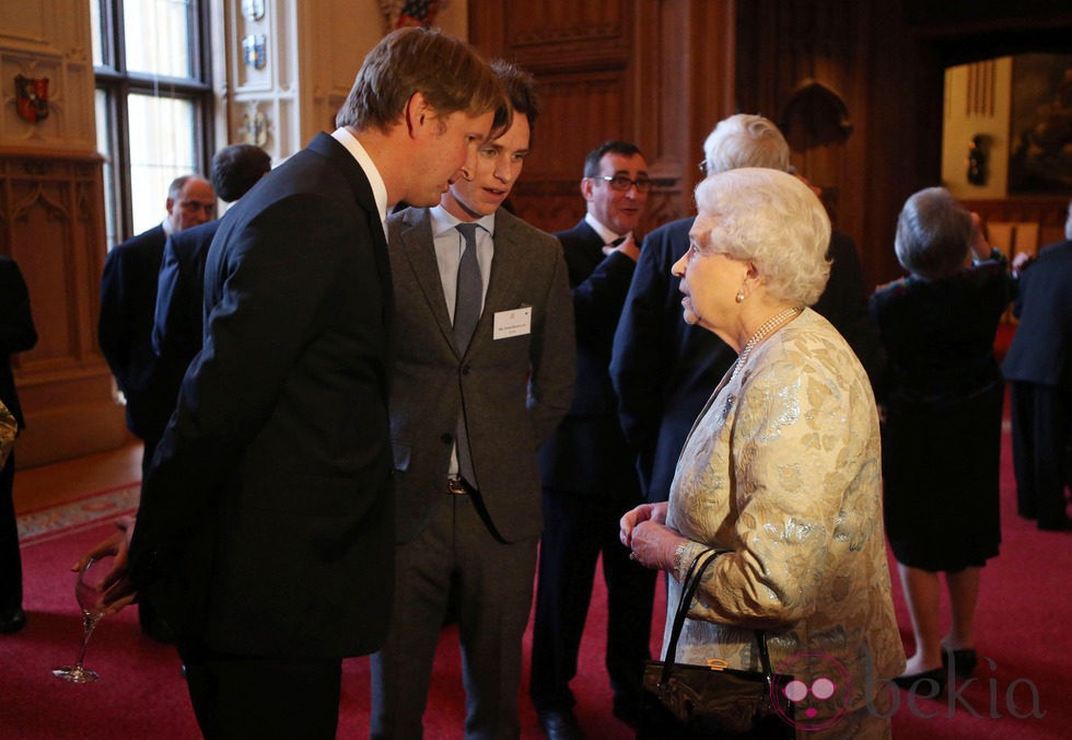 Isabel II de Inglaterra con Tom Hooper y Eddie Redmayne tras recibir un BAFTA honorífico