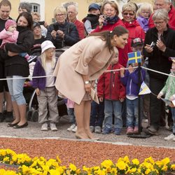 Victoria de Suecia saluda a unos niños en la inauguración de una exposición sobre la Princesa Estela