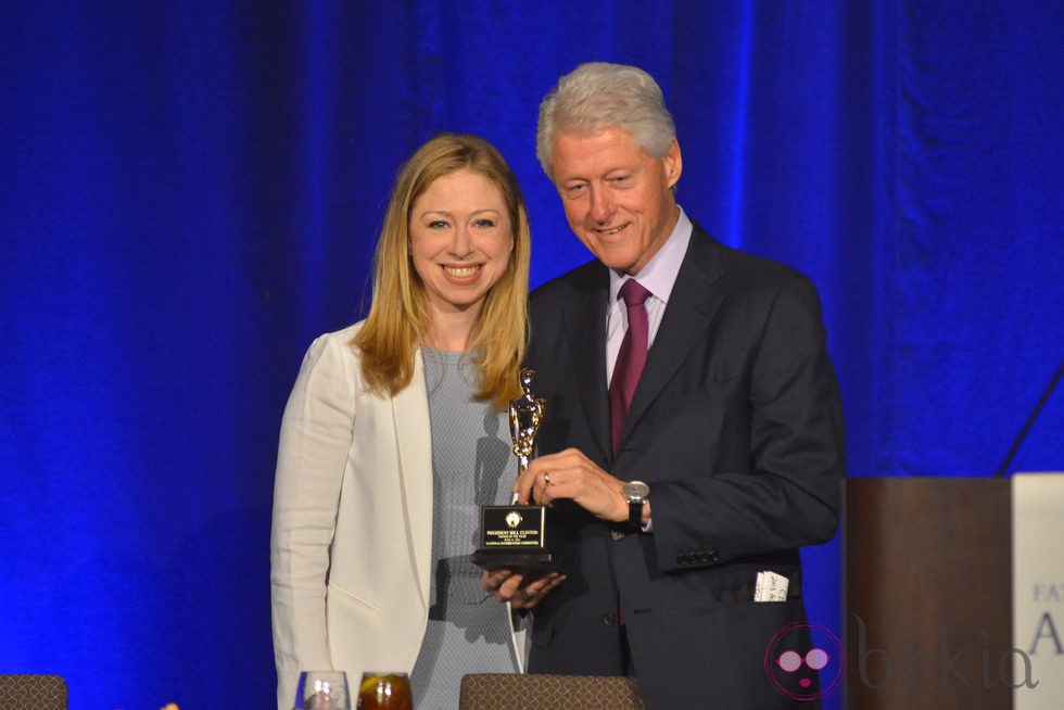 Bill Clinton con su hija Chelsea sosteniendo el galardón a 'Padre del Año'