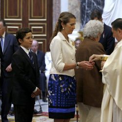 Las Infantas Elena y Cristina y Froilán comulgando en la misa conmemorativa del centenario del nacimiento del Conde de Barcelona