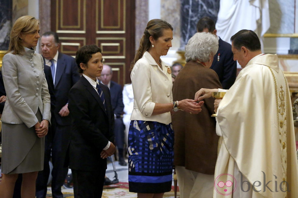 Las Infantas Elena y Cristina y Froilán comulgando en la misa conmemorativa del centenario del nacimiento del Conde de Barcelona