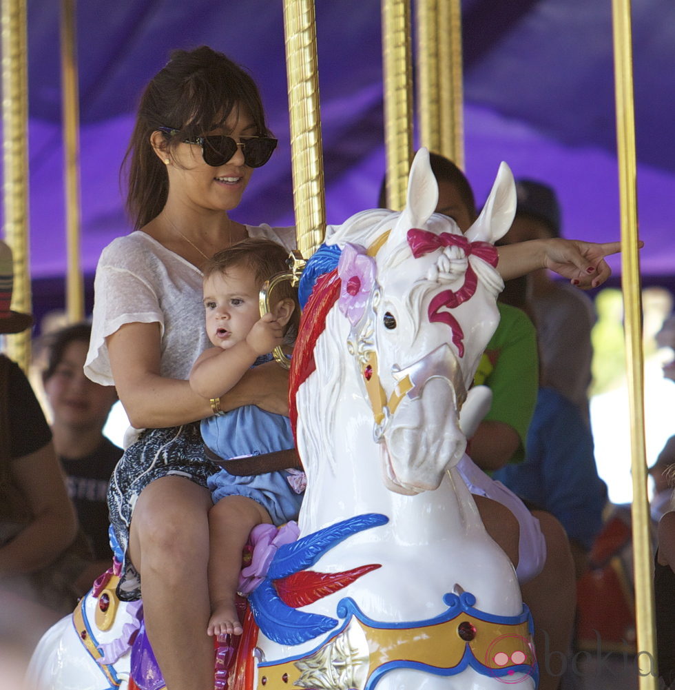 Kourtney Kardashian con Penelope Dissick en el tiovivo de Disneyland California