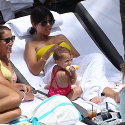 Kourtney Kardashian tumbada al sol con su hija Penelope Disick en una piscina de Miami