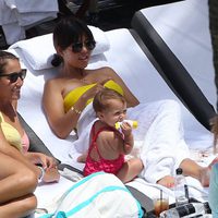 Kourtney Kardashian tumbada al sol con su hija Penelope Disick en una piscina de Miami