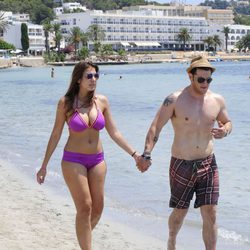 Manu Tenorio y Silvia Casas pasean cogidos de la mano por una playa de Ibiza