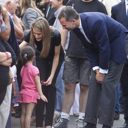 Los Príncipes Felipe y Letizia saludan a una niña en el lugar del accidente ferroviario